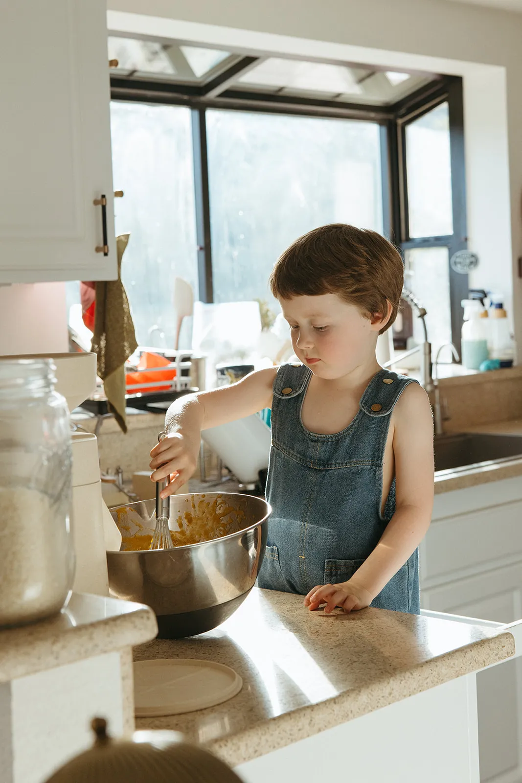A child stirring batter in a mixing bowl