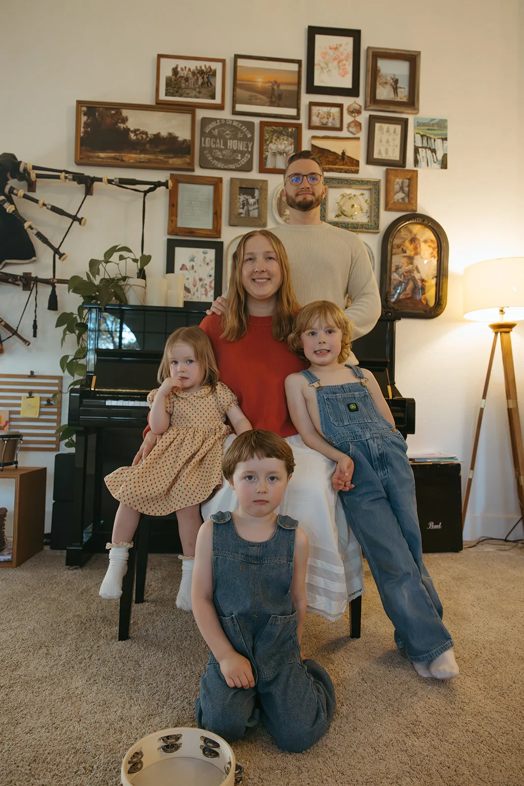 A family gathered by the piano beneath a gallery wall