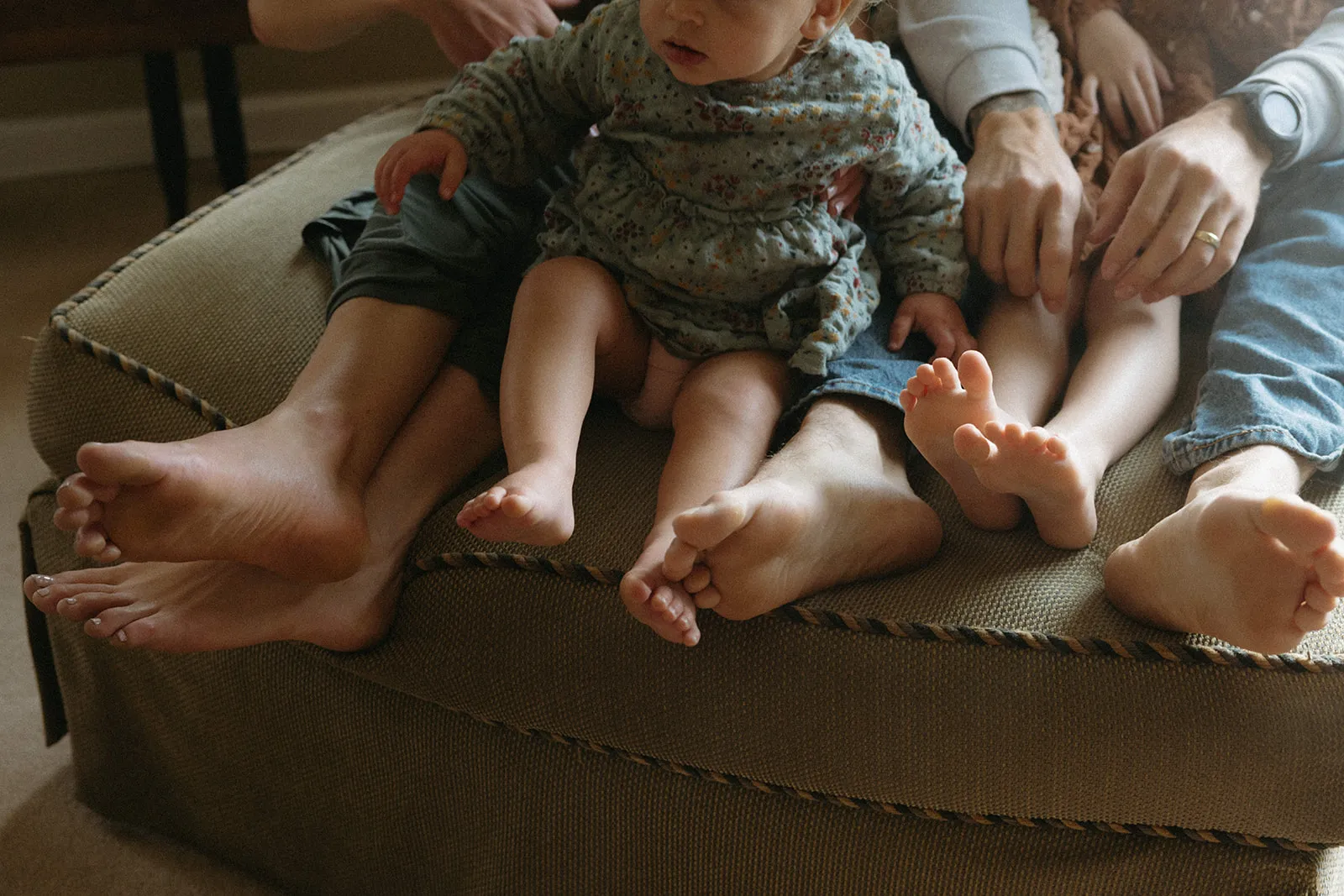 Bare feet resting together on a couch