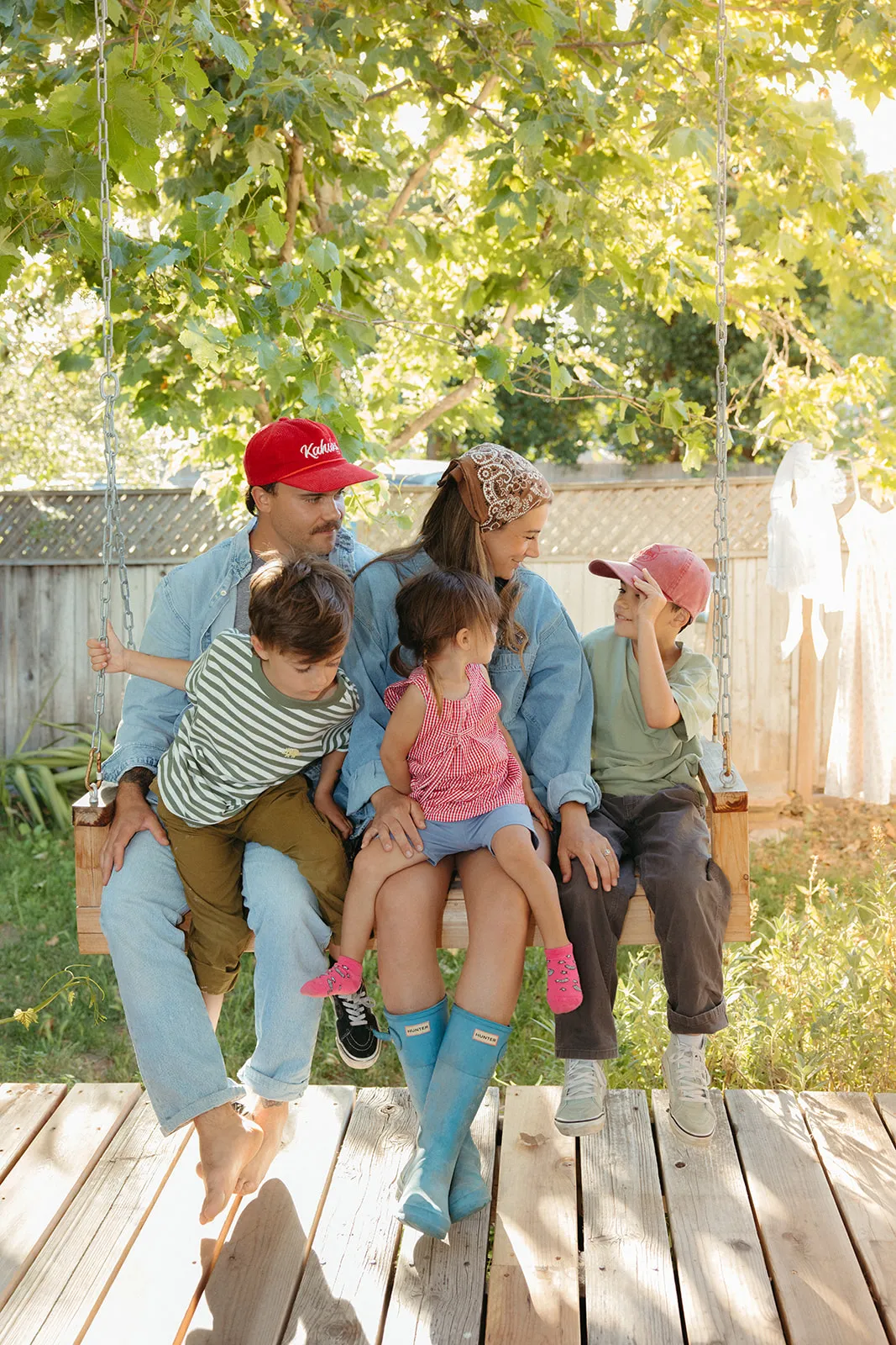 A family crowded together on a backyard swing