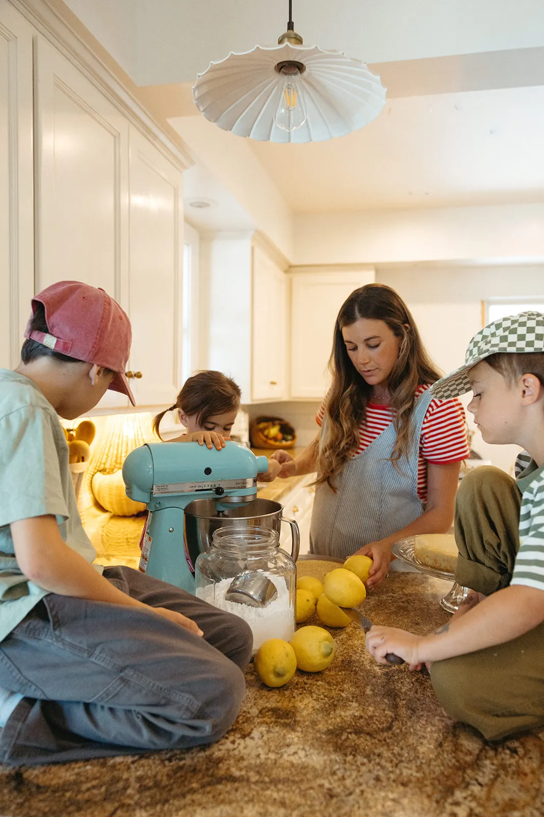 A family squeezing lemons together in the kitchen